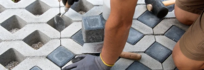 Person verlegt Rasengittersteine